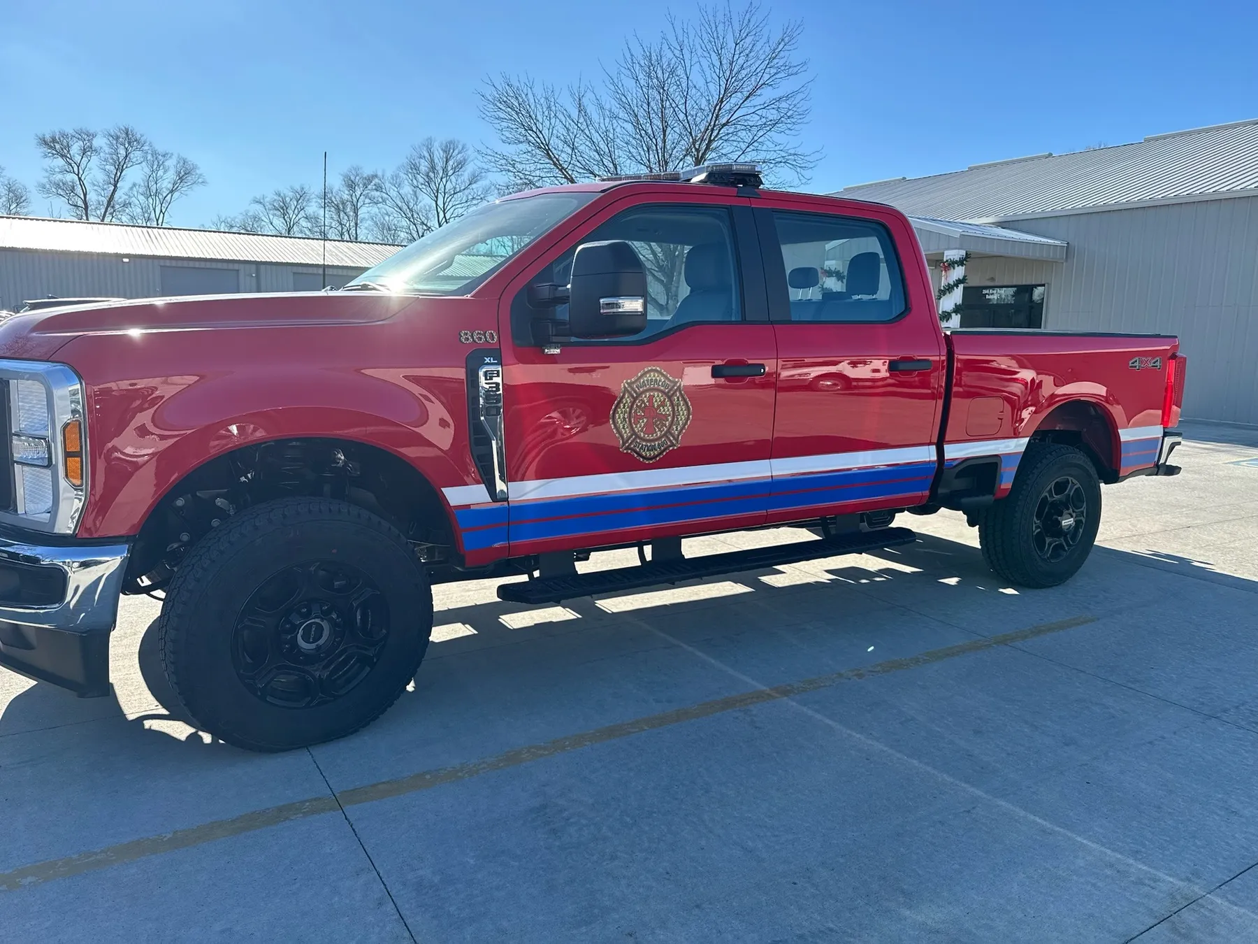 Red fire rescue truck with reflective chevron striping and warning lights by Elite Vehicle Outfitters