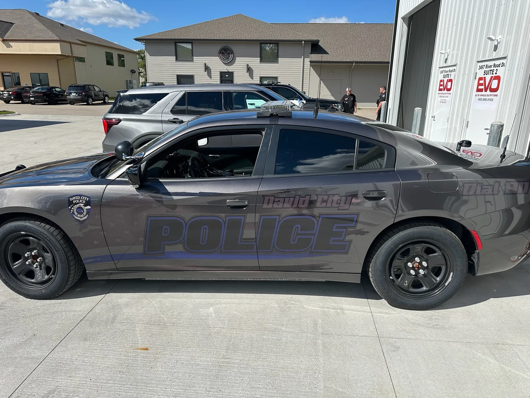 Marked police Dodge Charger with graphics and warning lights by Elite Vehicle Outfitters
