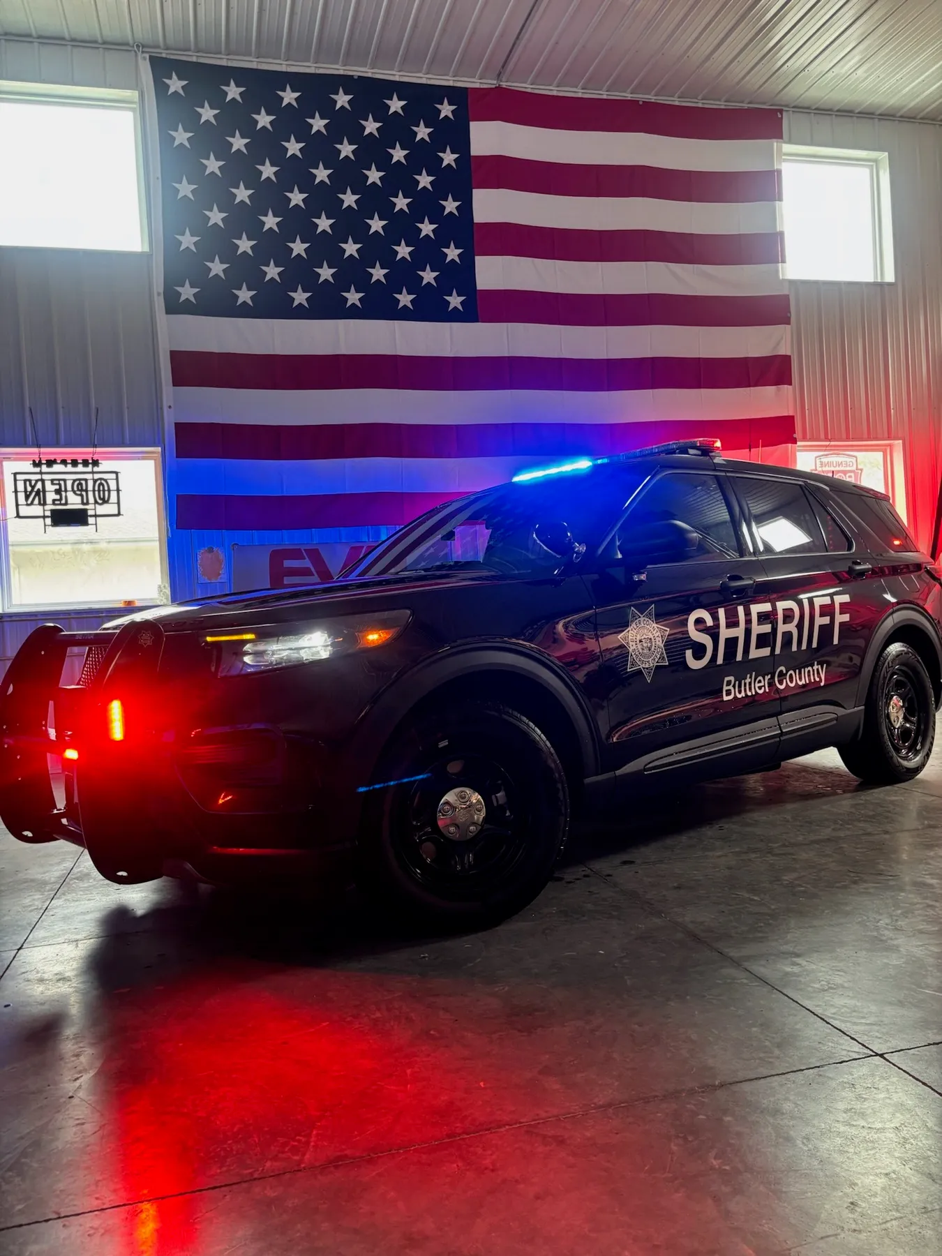 Butler County Sheriff Ford Police Interceptor Explorer with red and blue emergency lighting activated, built by Elite Vehicle Outfitters